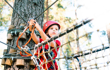 Obraz na płótnie Canvas Little boy climbing rope trail.