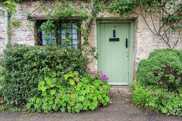 BIBURY, COTSWOLDS, UK - MAY 28, 2018: Traditional cotswold stone cottages built of distinctive...