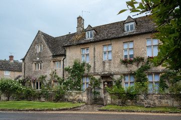 Fototapeta na wymiar BIBURY, COTSWOLDS, UK - MAY 28, 2018: Traditional cotswold stone cottages built of distinctive yellow limestone in the lovely village of Bibury, Gloucestershire, England 