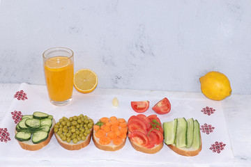 Fried bread, carrots, and cucumbers, tomatoes and peas with lemon juice, green sandwiches, the concept of a healthy diet and weight loss, healthy diet foods on a light background, I love my body.