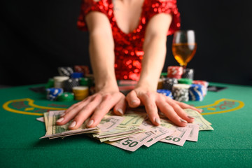 A girl wins cards in a casino and takes away wins, money, dollars. Blackjack. poker. texas poker. gaming business