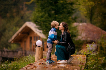 happy family, mother and son outdoors in autumn in the pouring rain, Rosa Khutor, Sochi, October...