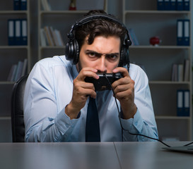 Businessman gamer staying late to play games