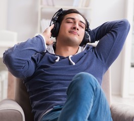 Young man listening to music at home