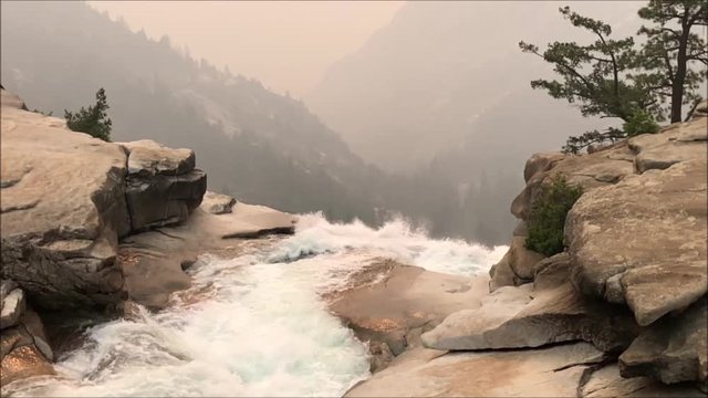 The view from the top of Nevada Falls, smoke coming from the Ferguson Fire visible in the background; Yosemite National Park, California; slow motion