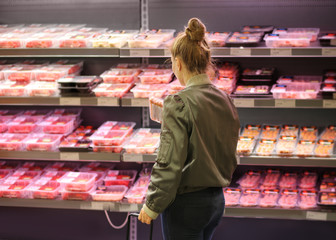 Woman purchasing a packet of meat at the supermarket