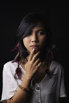 Native American woman's face With freckles on the face And jewelry made of leather and feathe