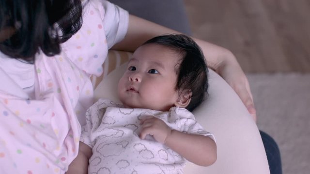 4k Asian little infant baby girl on her mother's lap at home, daytime, after breast feeding, breakfast, lunch, black hair woman, natural light, indoor