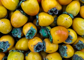 Persimmon phonis in the market. Ripe fruits on the counter.