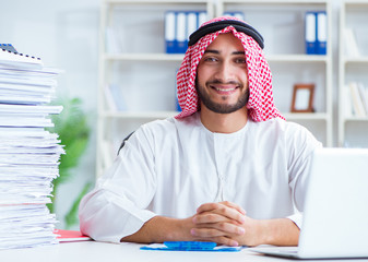 Arab businessman working in the office doing paperwork with a pi