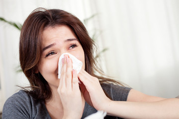 young woman blowing her nose