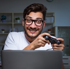 Young man playing games long hours late in the office