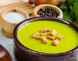 Spinach soup served on wooden board