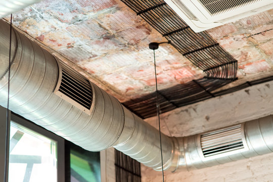 pipes of the ventilation system above the ceiling of the loft bar room, details of the engineering systems of ventilation.