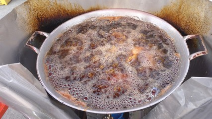 View footage of hand seller frying Chicken in boiling hot oil, street food in Thailand - 4k.