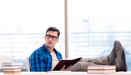 Student studying in the empty library with book preparing for ex