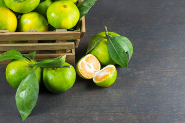 fresh ripe juicy yellow mandarin ( clementine, tangerine ) on wooden rustic vintage table with leaf. Tangerines citrus fruit background concept