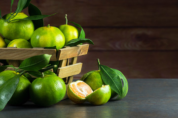 fresh ripe juicy yellow mandarin ( clementine, tangerine ) on wooden rustic vintage table with leaf. Tangerines citrus fruit background concept