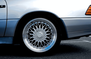 Fototapeta na wymiar Detail of a rear fender and wheel of a perfect silver luxury sports car.