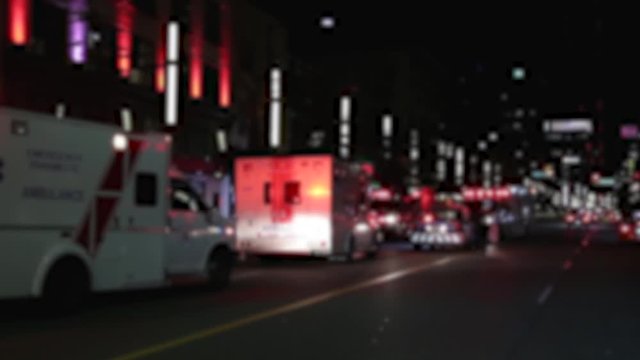 A intentionally blurred out background of emergency vehicles on a busy city street at night.