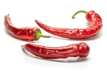 Group of three whole intense red fresh hot pepper isolated on white background