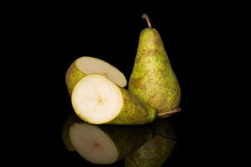 Group of one whole two halves of fresh green pear conference isolated on black glass