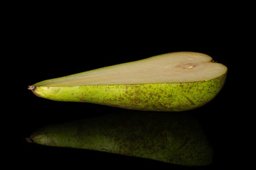 One half of fresh green pear conference isolated on black glass