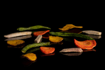 Lot of whole dry vegetable chip isolated on black glass