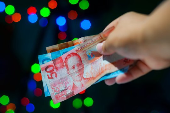 Giving monetary gift in Christmas. Handing out cash as a gift for Holiday. Filipino tradition called Pamasko. 
