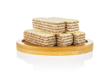 Group of five whole crispy beige hazelnut wafer cookie on bamboo coaster isolated on white background