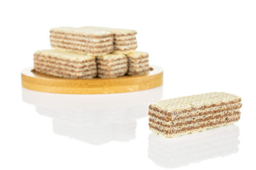 Group of six whole crispy beige hazelnut wafer cookie on bamboo coaster isolated on white background