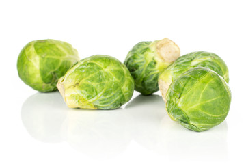 Group of four whole fresh green brussels sprout heap isolated on white background