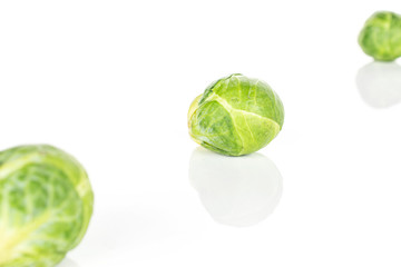 Group of four whole fresh green brussels sprout diagonal isolated on white background