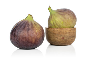 Group of two whole sweet purple fig in bamboo bowl isolated on white background