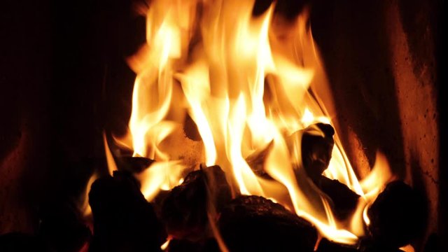 footage of an open fire in a fireplace in an old irish cottage showing yellow flame on black coal