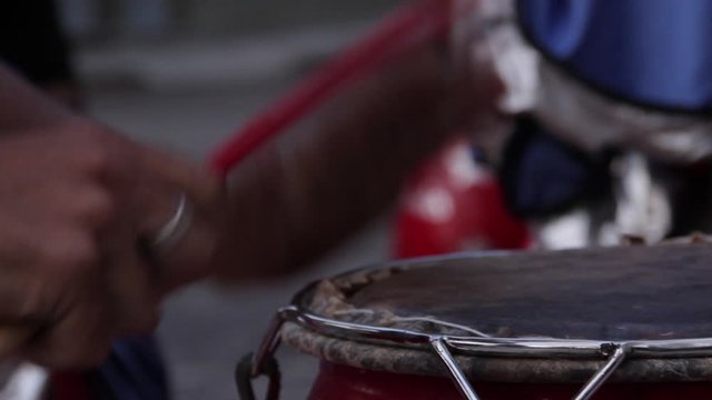 Male Hands holding Drum Sticks while Playing Traditional Drum. Close-Up. Filmed in Latin America.