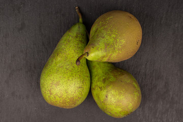 Group of three whole fresh green pear flatlay on grey stone