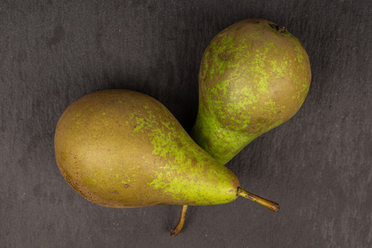 Group of two whole fresh green pear flatlay on grey stone