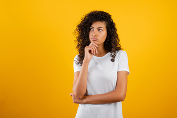 young black woman thinking isolated over yellow