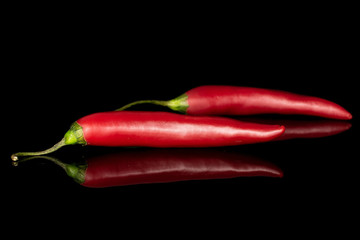 Group of two whole hot red chili cayenne isolated on black glass