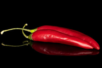 Group of two whole hot red chili cayenne front focus isolated on black glass