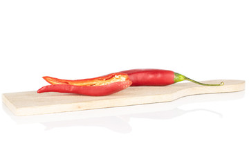 Group of two whole hot red chili cayenne on wooden cutting board isolated on white background