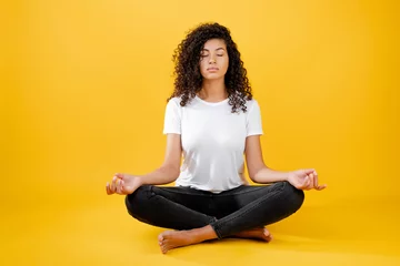 Fototapeten entspannte schwarze Frau, die in Yoga-Pose meditiert, isoliert über gelb © Anastasia