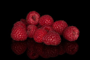 Group of nine whole fresh red raspberry isolated on black glass