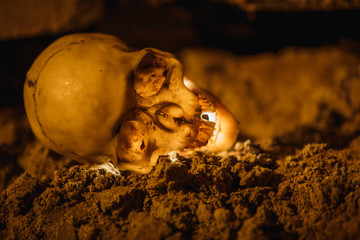 The light on the ground in the dark basement glows yellow from the inside. Terrible picture of a layout of a skull for Halloween.