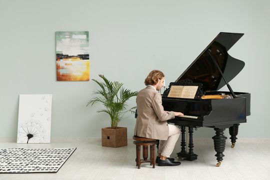 Man playing grand piano at home