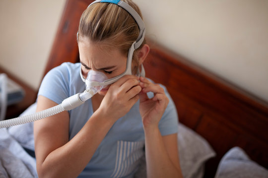Putting on cpap mask with discomfort.
