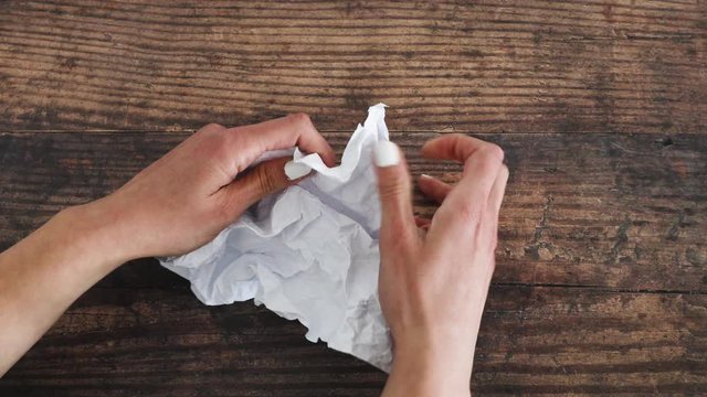 lack of creativity concept, hand scrunching up a paper sheet on desk