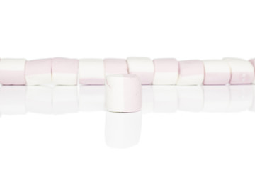 Group of eleven whole sweet pastel marshmallow one in focus isolated on white background