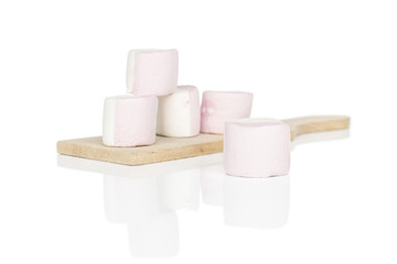 Group of five whole sweet pastel marshmallow on wooden cutting board isolated on white background